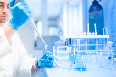 Test tüpleri Kliniği, eczane ve pipet kullanarak erkek bilim adamı ile tıbbi araştırma laboratuvarı