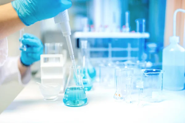 Doctor using electronic pipette for taking samples from test tube in special chemical laboratory or private clinic — Stock Photo, Image