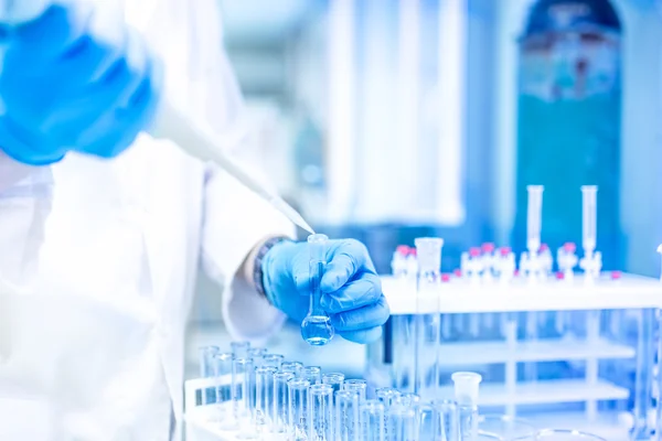 Médico Cientista e químico em laboratório usando uma pipeta ou conta-gotas para amostras líquidas — Fotografia de Stock