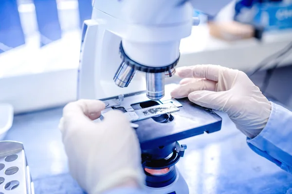 Mãos cientista com microscópio, examinando amostras e líquido. Pesquisa médica com equipamentos técnicos — Fotografia de Stock