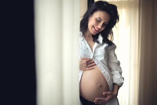 Mãe feliz de mãos dadas, barriga grávida. Retrato acolhedor de bela mulher grávida sendo feliz — Fotografia de Stock