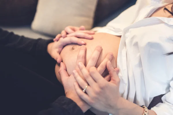 Счастливый будущий отец, держась за руки и трогая живот беременной жены, концепция материнства . — стоковое фото