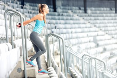 Fitness Kız Fitness egzersizleri yapıyor ve stadyum merdivenlerde çalışma dışarı. Koşucu sabah eğitim, sağlıklı yaşam rutin kavramı