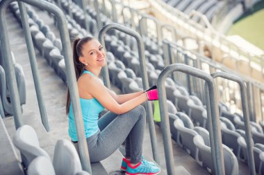 İstirahat kadın fitness eğitmeni ve excercising. sporcumuz zevk iyi, kaliteli iş günü stadyum merdiven