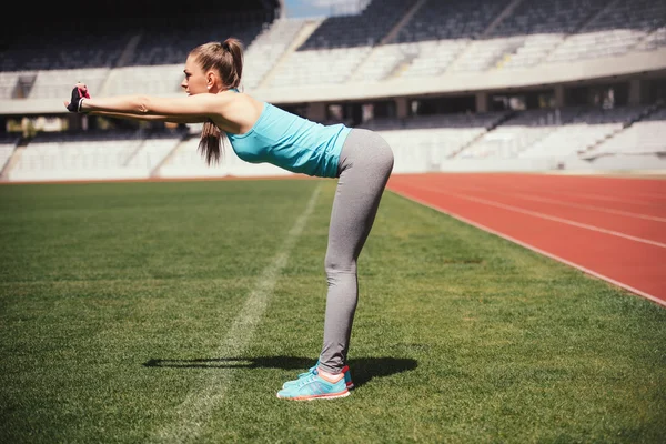 Corredor femenino estirándose, preparándose para el entrenamiento. Deportista de fitness calentándose para correr . —  Fotos de Stock