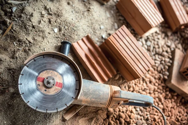 Angle grinder used on construction site for cutting bricks, debris. Tools and bricks on new building site — Stock Photo, Image