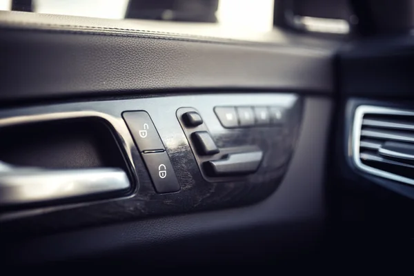 Detalles interiores de cuero del coche de la manija de la puerta con controles de ventanas, ajustes del asiento. modernos controles de ventanas y puertas de coches modernos —  Fotos de Stock