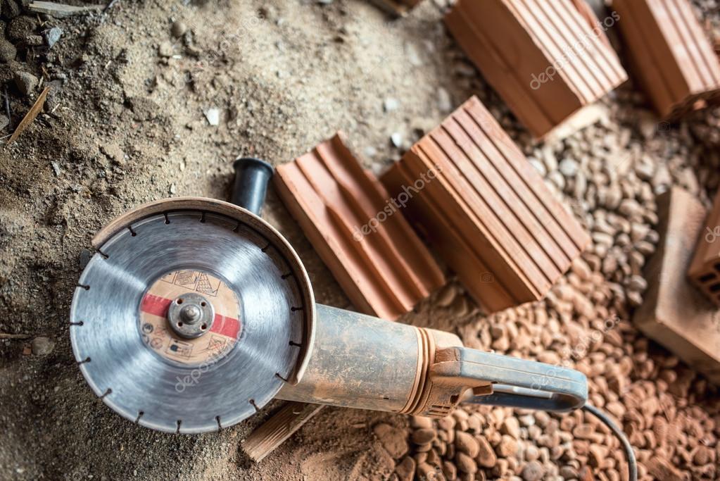 Angle grinder used on construction site for cutting bricks, debris