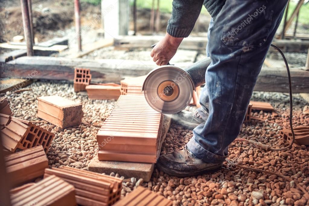 Industrial worker using an grinder for cutting and sawing construction