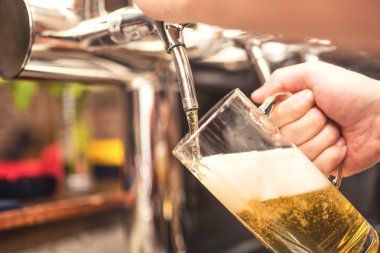 soğuk, soğuk bira hizmet bistro garson. Barmen bir lager bira musluk üzerinden dökülen el