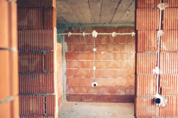 Installation de fils électriques et de tuyaux d'électricité sur le chantier de construction d'une maison neuve . — Photo
