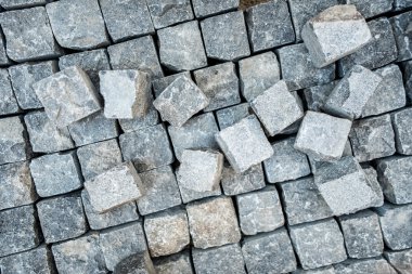 Road pavement, stone blocks and construction tools. Construction worker laying cobblestone pavement stones