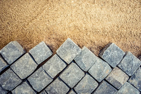 Construção de detalhes do pavimento, pavimento de paralelepípedos, blocos de pedra no canteiro de obras rodoviárias — Fotografia de Stock