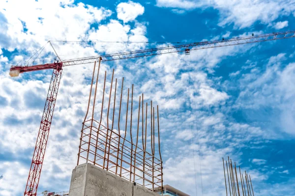 Muro di cemento industriale con primo piano in acciaio armato, gru e cantiere di edifici — Foto Stock