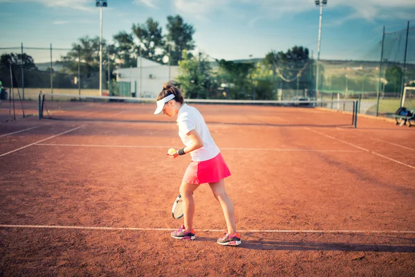 Mulher jogando tênis na quadra de barro, com roupa esportiva e estilo de vida saudável — Fotografia de Stock