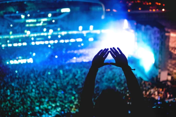 Man showing love at concert, silhouette of hands making gestures with lights background — Stock Photo, Image