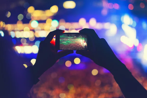 Hombre sosteniendo el teléfono y grabando un concierto, tomando fotos y disfrutando de la fiesta del festival de música —  Fotos de Stock