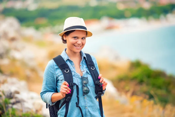 Mujer sonriente, excursionista en camino, montañas con mochila. Con —  Fotos de Stock