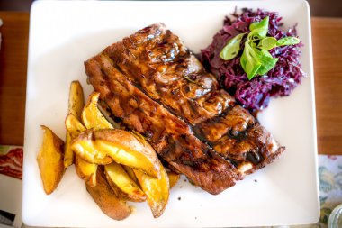 Barbekü Domuz kaburga Restoran, ana yemek olarak. Domuz eti lezzet lezzetli barbekü sosu, maydanoz, lahana ve patates ile