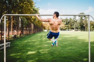 Erkek atlet çekme işi ups, çene ups parkta. Çalışma dışarı ve parkta eğitim fitness atheltic adam. Çapraz uygun kavram