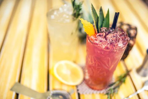 strawberry and pineapple alcoholic beverage, served cold with ice at bar. Cocktail drinks with lime, pineapple and alcohol as refreshment drinks on a summer day