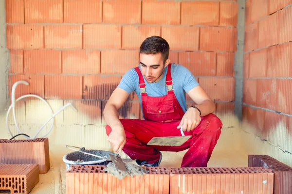 Konstruktion mason, industriarbetare med verktyg bygga väggar — Stockfoto