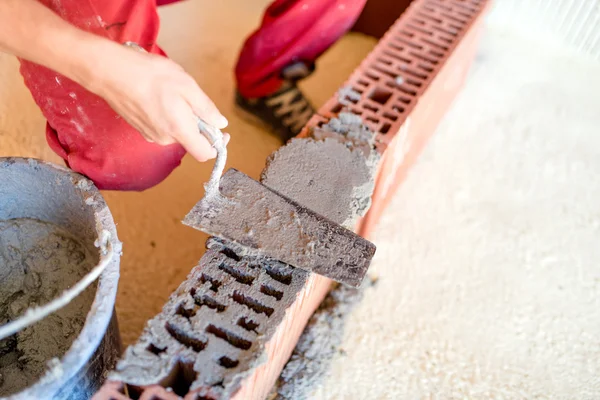 Industriële werknemer met spatel en putty mes met behulp van mortel voor het maken van bakstenen muren — Stockfoto