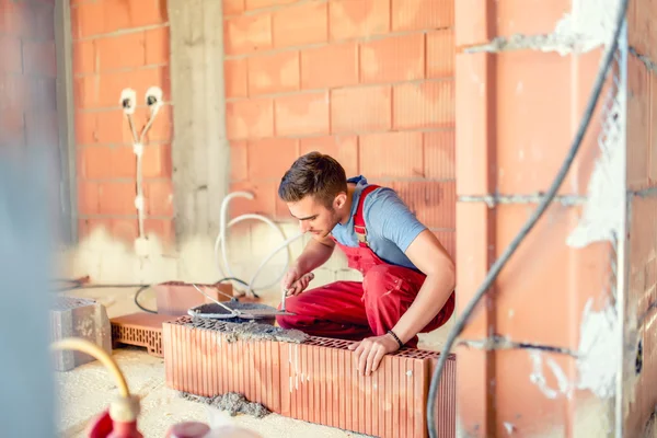 Stenhuggare builing väggar, byggnadsingenjör och arbetare på plats — Stockfoto