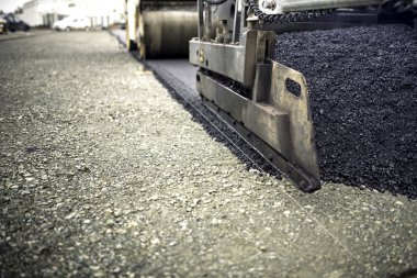 industrial pavement truck laying fresh asphalt, bitumen during road works. Construction of highways and road works clipart
