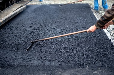 Taze asfalt bir yol inşaat sitesinde, endüstriyel tesviye bina