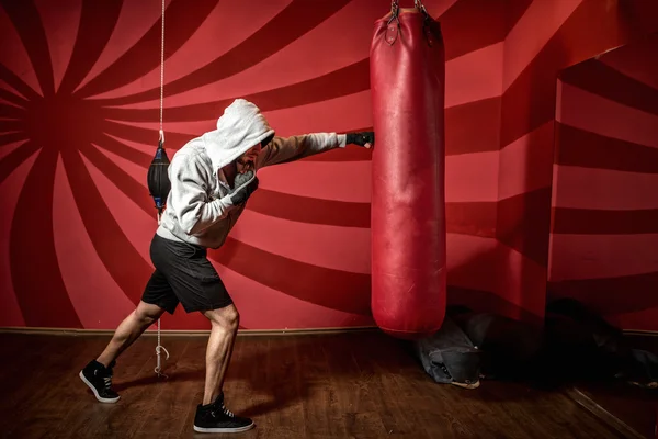 Entrenamiento de boxeador profesional en el gimnasio, la práctica de patadas y golpes —  Fotos de Stock