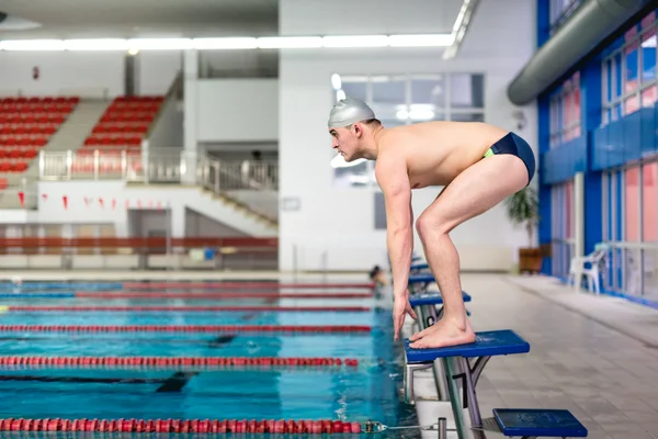 Aktiver Schwimmer bereitet sich auf Sprung ins Becken vor — Stockfoto