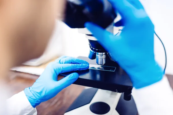 Cientista usando microscópio para examinar pequenas sondas químicas. Equipamento médico e amostras de laboratório — Fotografia de Stock