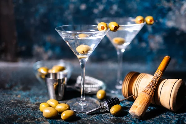 Bebida de coquetel Martini com azeitonas enfeite e ferramentas em fundo enferrujado — Fotografia de Stock