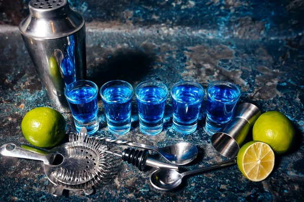 Närbild av blå curacao alkoholhaltiga drycker, shot blå cocktails och lime — Stockfoto