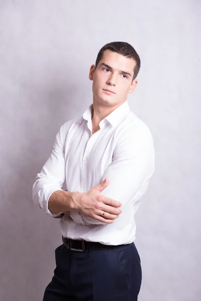 handsome young handsome brunette man in white shirt and black trousers. Business portrait. business style. office. on a white background