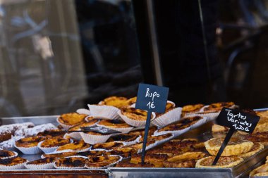 Çeşitli hamur işleri, kurabiyeler ve turtalarla dolu konforlu fırın vitrini.