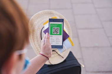Kadın, uygulama telefonundan havaalanından COVID-19 ekspres test sonuçları hakkında bir mesaj almış. Yaz tatili konseptine hazırım.