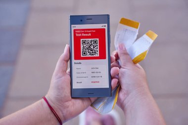 Uygulama telefonundan COVID-19 test sonuçlarıyla ilgili bir mesaj almış. Yırtık bir uçuş kartı. Başarısız tatil planları, iptal edilmiş uçuş konsepti