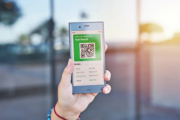 Hand woman holds smartphone displaying an app negative test result of covid-19. Express PCR test, digital result on mobile application