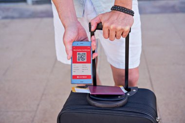 Çanta ve akıllı telefon cep telefonunda Covid-19 için süresi geçmiş dijital aşı sertifikası var. Dokunulmazlık aşısı pasaportu, aşı sertifikası, seyahat için sağlık pasaportu.