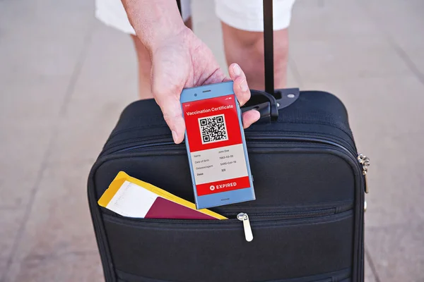 Covid 19のアプリモバイル有効期限が切れたデジタルワクチン接種証明書には オープンスーツケースとスマートフォンが手元に表示されます 免疫ワクチンパスポート 予防接種証明書 旅行のための健康パスポート — ストック写真