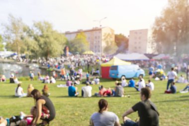 Bulanık bir grup insan açık hava pikniğinin ve açık hava festivalinin keyfini çıkarıyor.