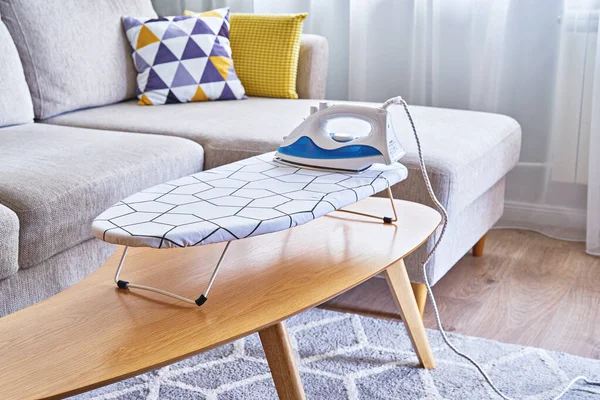 Iron for ironing on small tabletop ironing board in cozy and living room — Stock Photo, Image