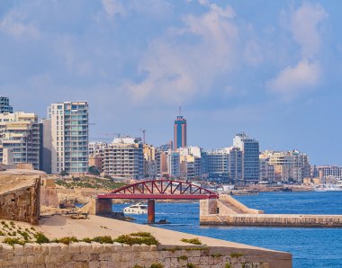 Kırmızı dalgakıran köprüsü, Grand Harbour 'u kireçtaşı duvarlarla ve şehir siluetiyle çevreleyerek mavi Akdeniz' in ötesine yükseldi.