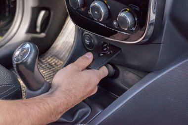 Erkek el, gösterge paneli ile anahtarsız uzaktan kumandayı tutar ve modern araba iç mekanında kontrolleri başlatır, güvenli giriş ve ateşleme konsepti