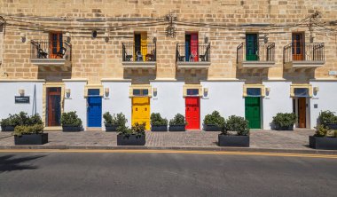 Marsaxlokk, Malta - 21 Mart 2024 'te Malta' nın Malta kıyı köyünde güpegündüz eski Malta daireleri ve küçük balkonları restore edildi.