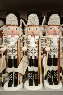 Perakende rafında kürk şapkalı beyaz ve gümüş fındıkkıran askerler, ahşap tatil figürleri, neşeli bir hava.
