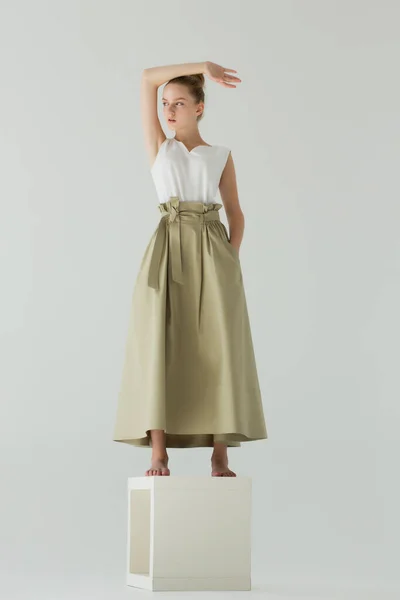 Stüdyoda Beyaz Bir Kübün Üzerinde Bir Kadın Duruyor Elbiseler Uzun — Stok fotoğraf