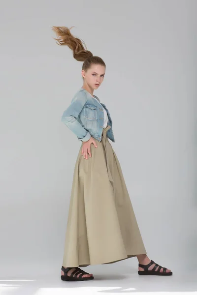 モデルの女の子は長いスカートと青いジュートの中に立っています 彼女は長い道のりを歩き 髪は動いている ファッションルック — ストック写真
